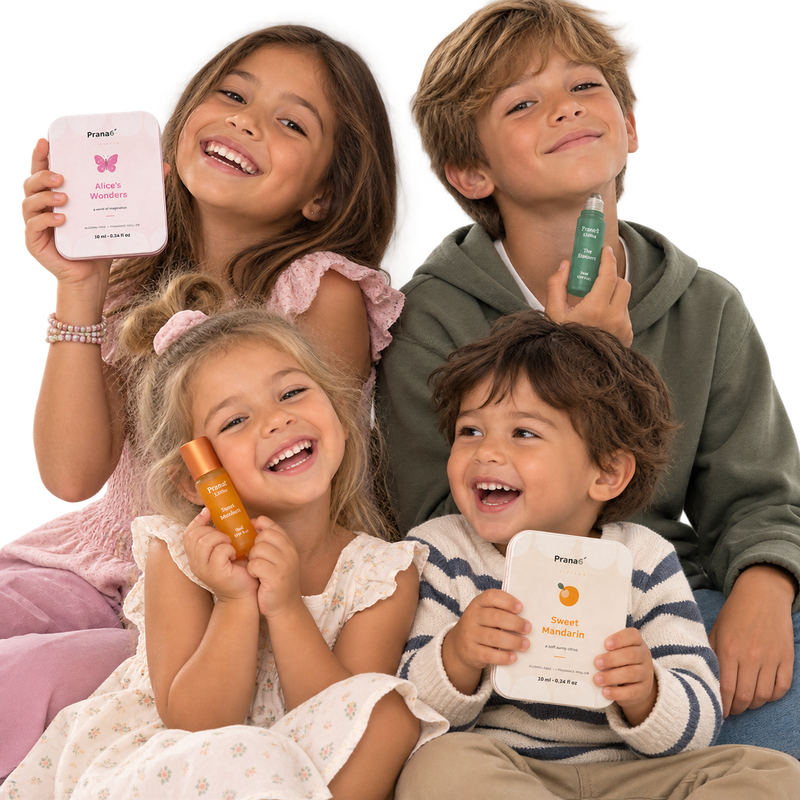 Four smiling kids holding Prana6 Littles roll-ons.